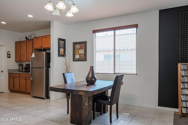 tiled dining room featuring an inviting chandelier