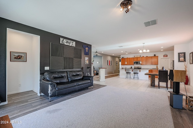 living room featuring light wood-type flooring and a chandelier