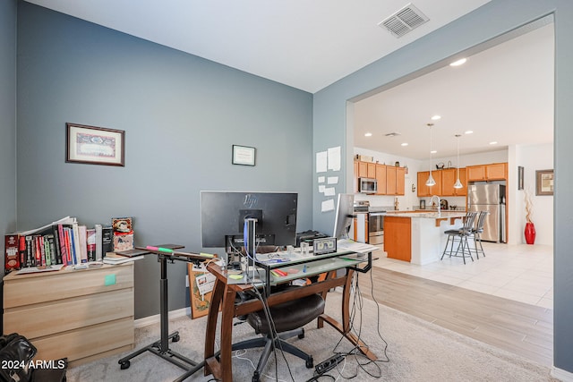 home office with sink and light hardwood / wood-style floors