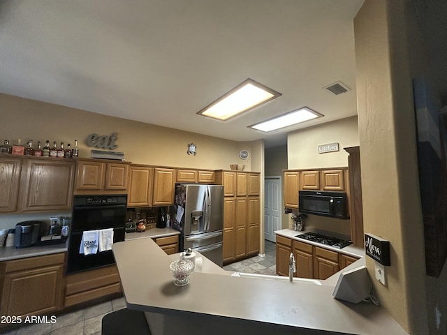 7326 W Dreyfus Dr, Peoria, AZ 85381 - kitchen with black appliances, light countertops, a peninsula, and brown cabinets