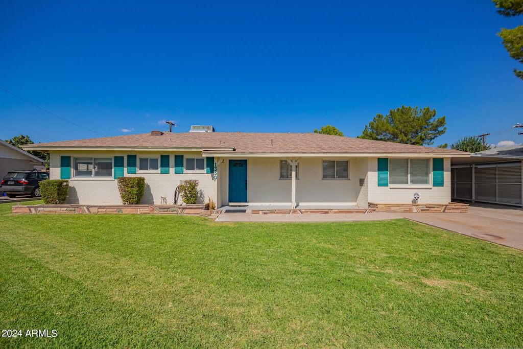 ranch-style house with a carport and a front lawn