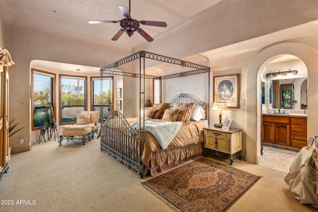 bedroom featuring ceiling fan, sink, light carpet, and connected bathroom