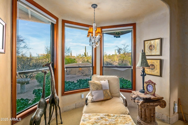 sitting room featuring a notable chandelier and carpet floors