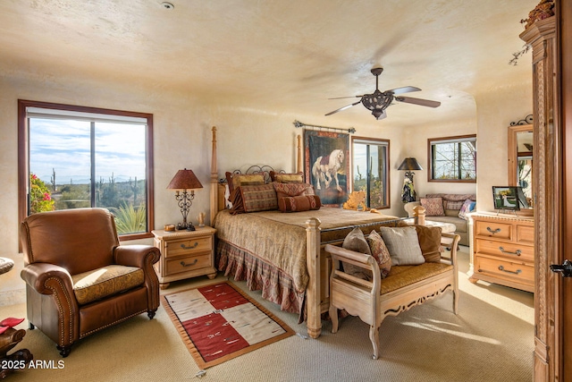 carpeted bedroom with ceiling fan and multiple windows