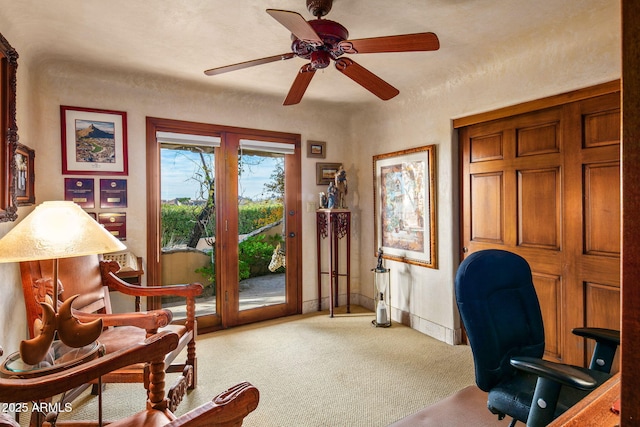 carpeted office space featuring ceiling fan