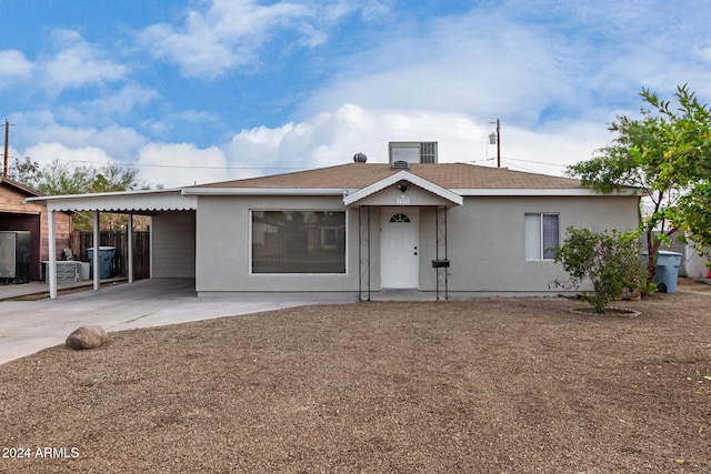 single story home featuring central AC unit and a carport