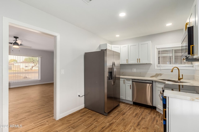 kitchen with white cabinets, sink, light wood-type flooring, and stainless steel appliances