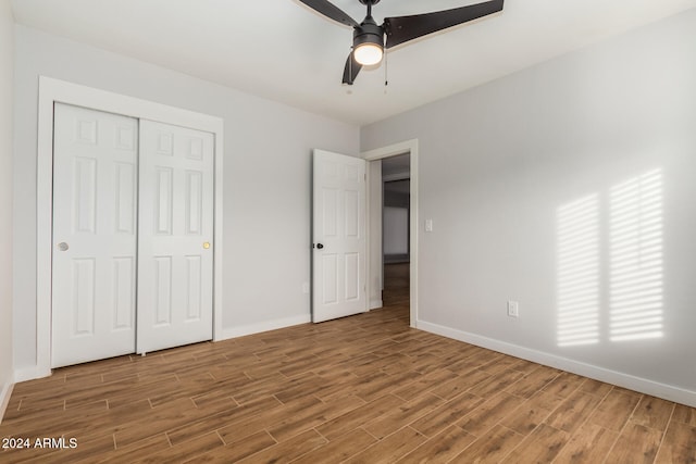 unfurnished bedroom with ceiling fan, wood-type flooring, and a closet