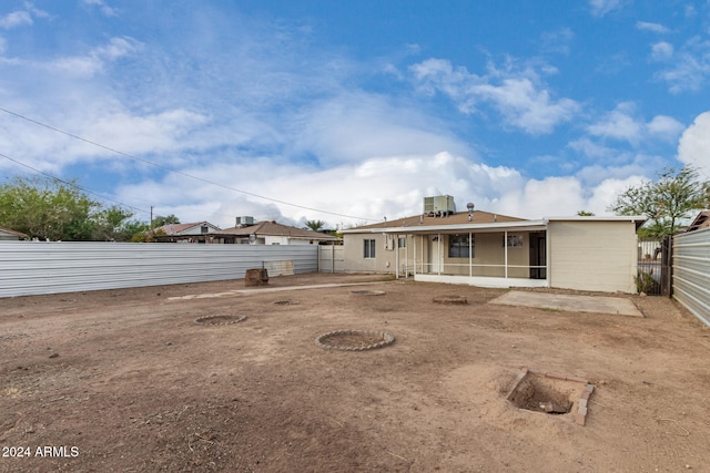 rear view of house featuring central air condition unit and a sunroom