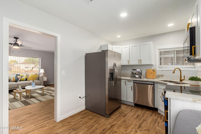 kitchen featuring white cabinetry, sink, light hardwood / wood-style flooring, and appliances with stainless steel finishes