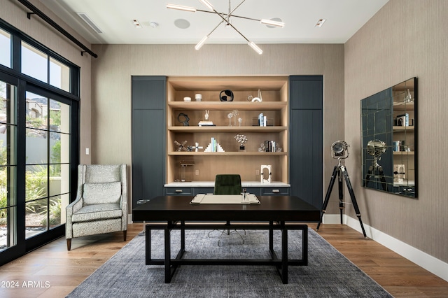 office featuring hardwood / wood-style flooring, an inviting chandelier, and sink