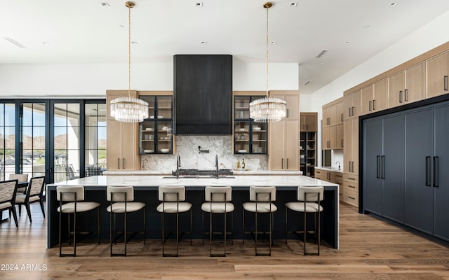 kitchen with a large island, hanging light fixtures, and light brown cabinetry