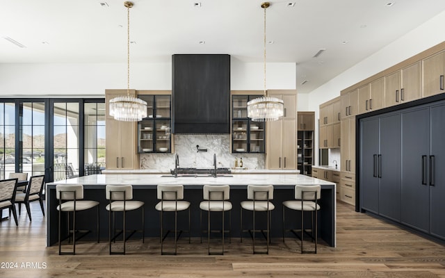 20958 N 112th St, Scottsdale, AZ 85255 - kitchen featuring a chandelier, wood finished floors, tasteful backsplash, and a large island with sink