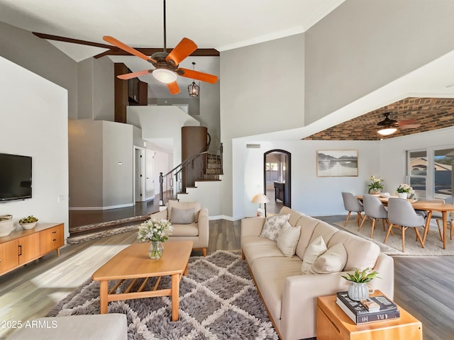 living area featuring ornamental molding, a ceiling fan, stairway, and wood finished floors