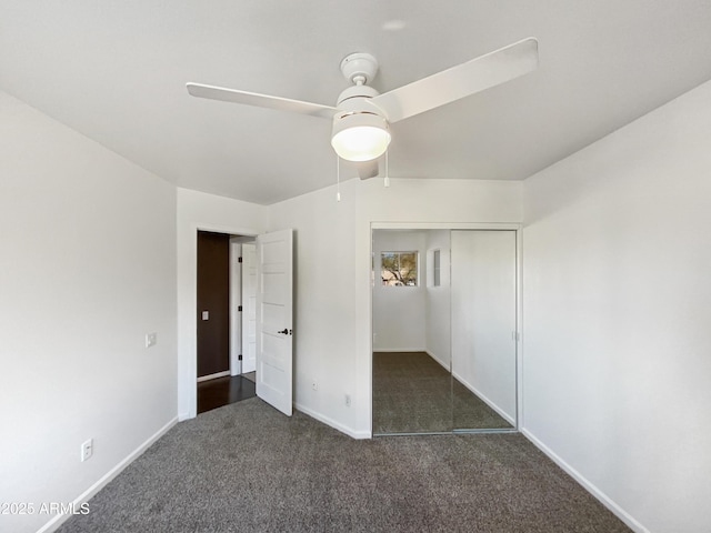 unfurnished bedroom featuring a ceiling fan, dark colored carpet, a closet, and baseboards