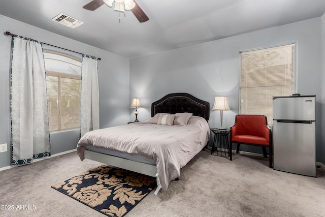 carpeted bedroom with visible vents, ceiling fan, and freestanding refrigerator