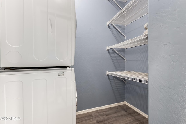 spacious closet with stacked washer and dryer and wood finished floors