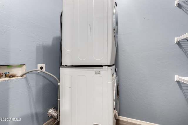 exterior space with stacked washer and dryer, laundry area, and a textured wall