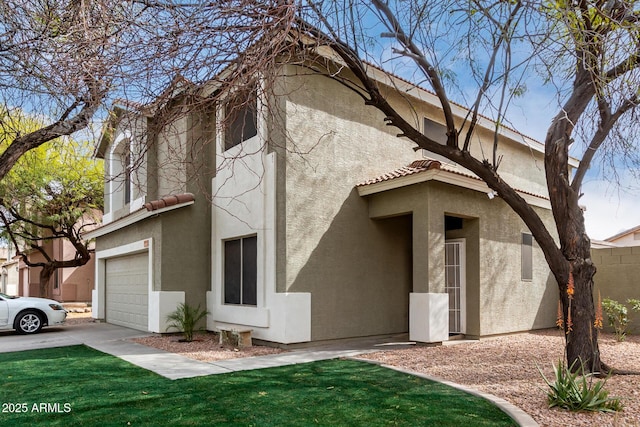 exterior space with a tiled roof, an attached garage, and stucco siding