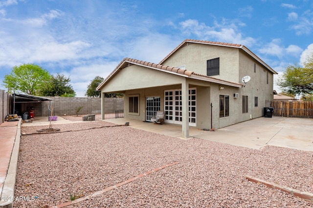 rear view of property featuring a tile roof, a patio area, a fenced backyard, and stucco siding