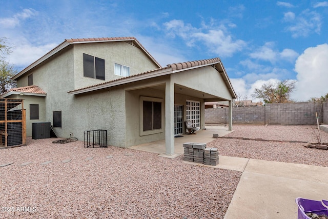 back of property featuring central AC unit, a patio, a fenced backyard, a tile roof, and stucco siding