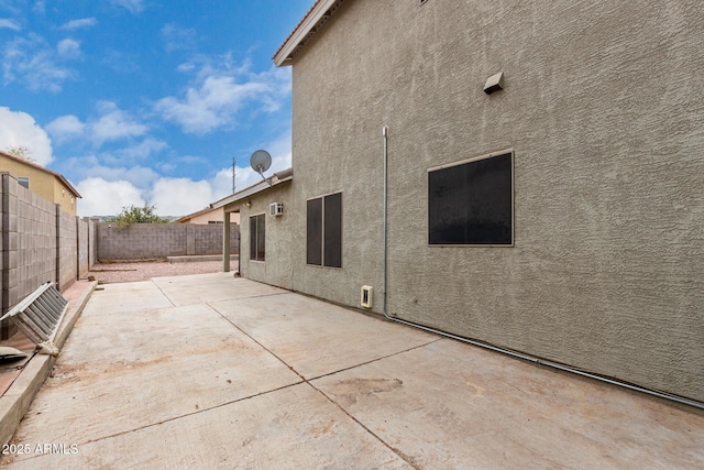 exterior space featuring a patio area, a fenced backyard, and stucco siding