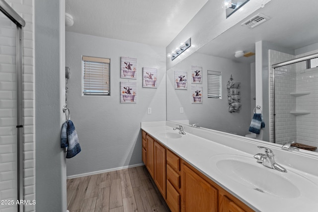 bathroom featuring a shower with door, wood-type flooring, and vanity