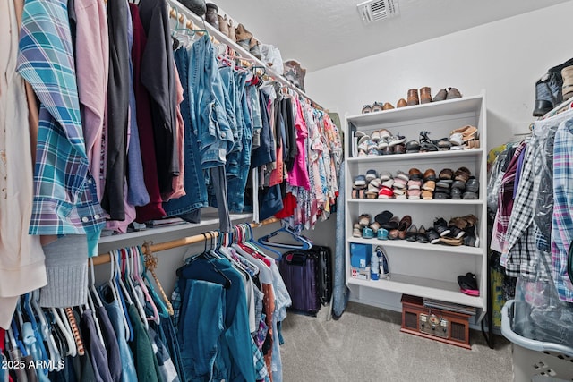 walk in closet featuring carpet flooring