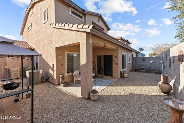 rear view of house with central AC, a gazebo, and a patio area