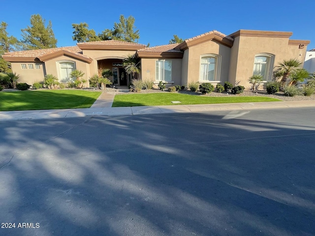 mediterranean / spanish house featuring a front lawn