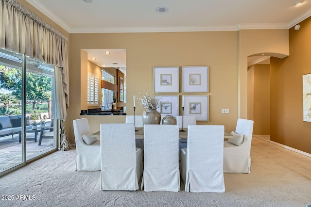 carpeted dining area with ornamental molding