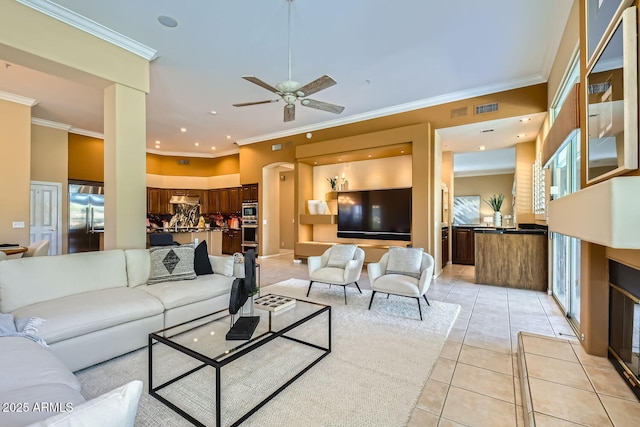 living room with light tile patterned flooring, ceiling fan, and crown molding