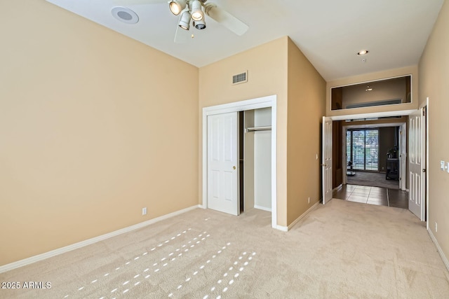 unfurnished bedroom with light colored carpet and a closet