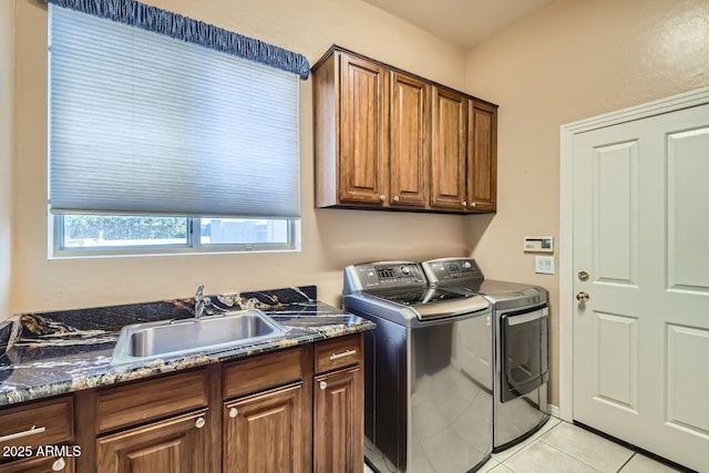 laundry area featuring cabinets, light tile patterned flooring, separate washer and dryer, and sink