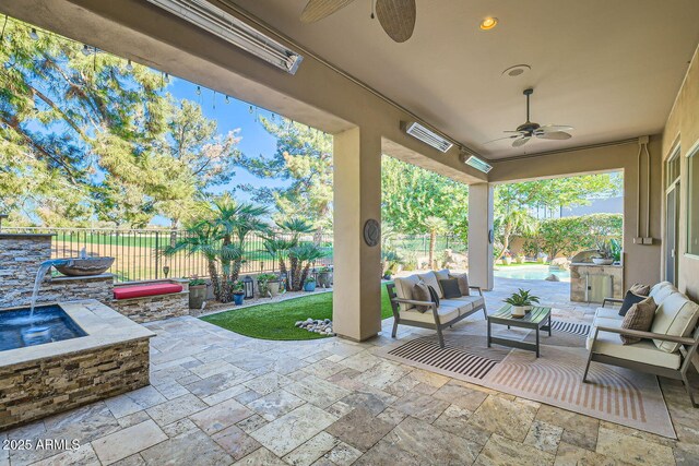 view of patio / terrace featuring outdoor lounge area, ceiling fan, and an outdoor kitchen