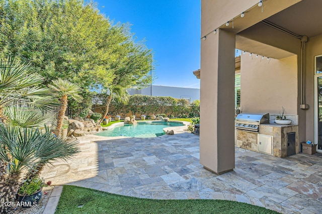 view of pool with an outdoor kitchen, a grill, and a patio area