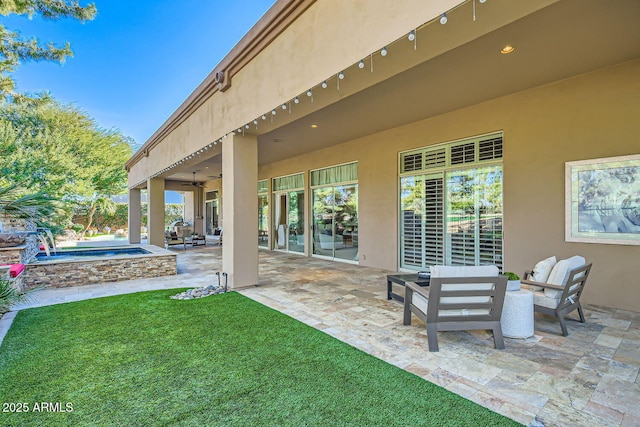 view of patio / terrace featuring an outdoor hangout area, ceiling fan, and an in ground hot tub