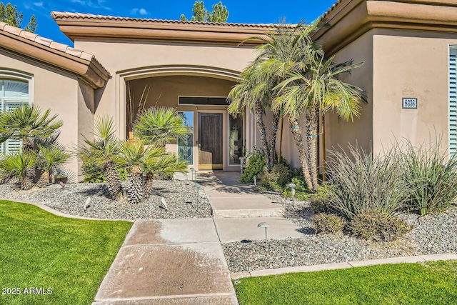 property entrance featuring a lawn