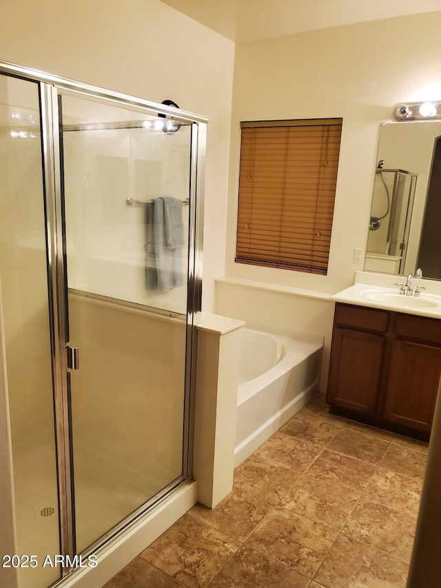 bathroom with vanity and shower with separate bathtub