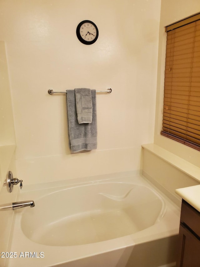 bathroom featuring vanity and a bath