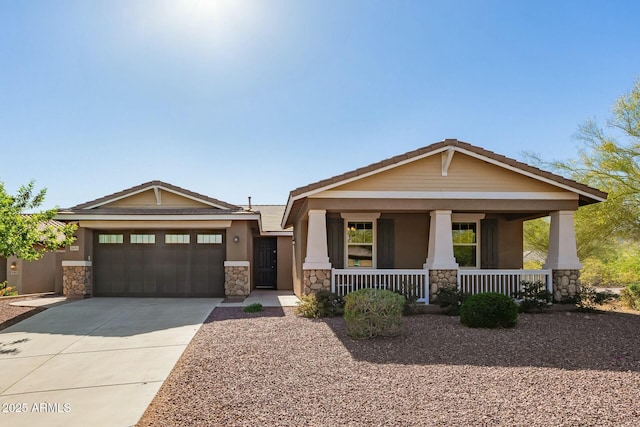 craftsman-style home with stone siding, a porch, driveway, and a garage