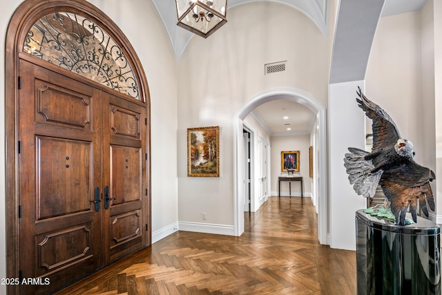 entrance foyer featuring dark parquet flooring and ornamental molding