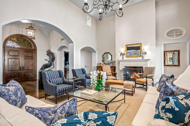 living room with a high ceiling, hardwood / wood-style flooring, and a chandelier