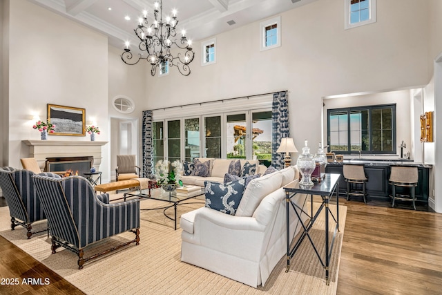 living room with a towering ceiling, light hardwood / wood-style floors, beamed ceiling, and coffered ceiling