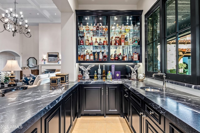 bar with a chandelier, decorative light fixtures, beamed ceiling, coffered ceiling, and sink