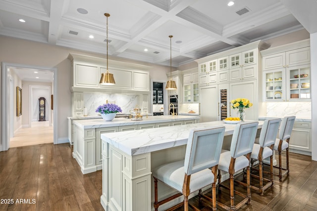 kitchen with coffered ceiling, hanging light fixtures, beamed ceiling, decorative backsplash, and a spacious island