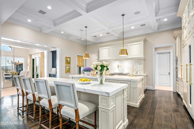 kitchen featuring beamed ceiling, a large island, coffered ceiling, and hanging light fixtures