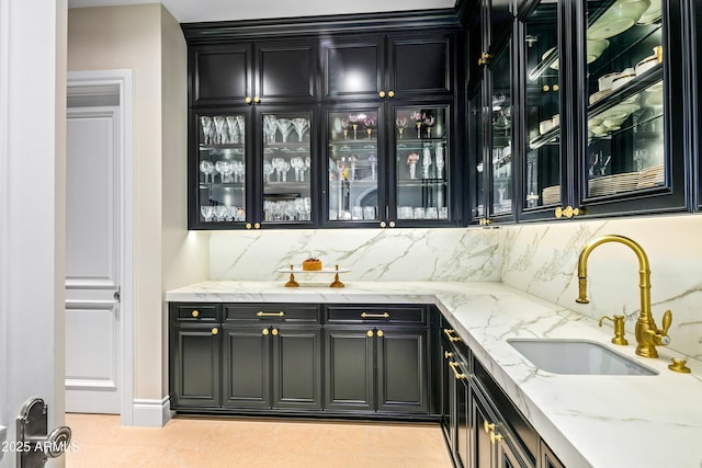 bar featuring sink, light stone counters, and decorative backsplash