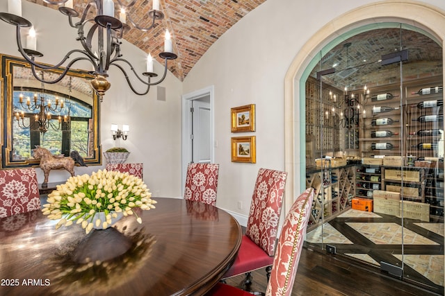 dining area featuring lofted ceiling, brick ceiling, a notable chandelier, and dark hardwood / wood-style flooring