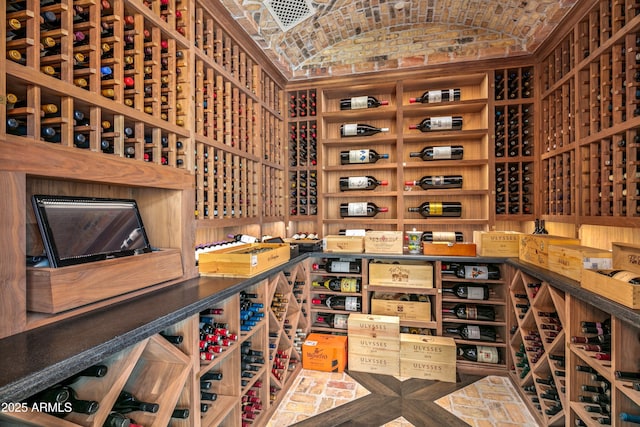 wine cellar featuring lofted ceiling and brick ceiling